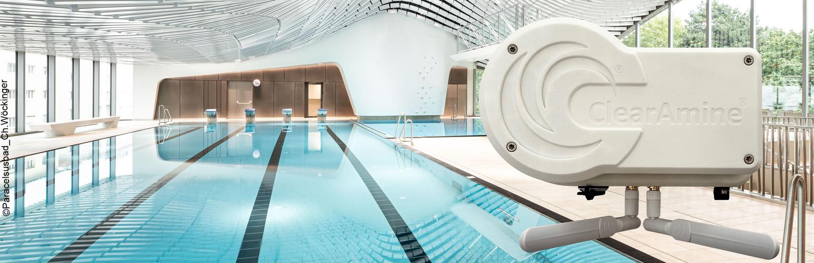 View through an indoor swimming pool. A man jumps head first into the pool. Text: "Paracelsus Bad und Kurhaus / Foto: Ch. Wöckinger"